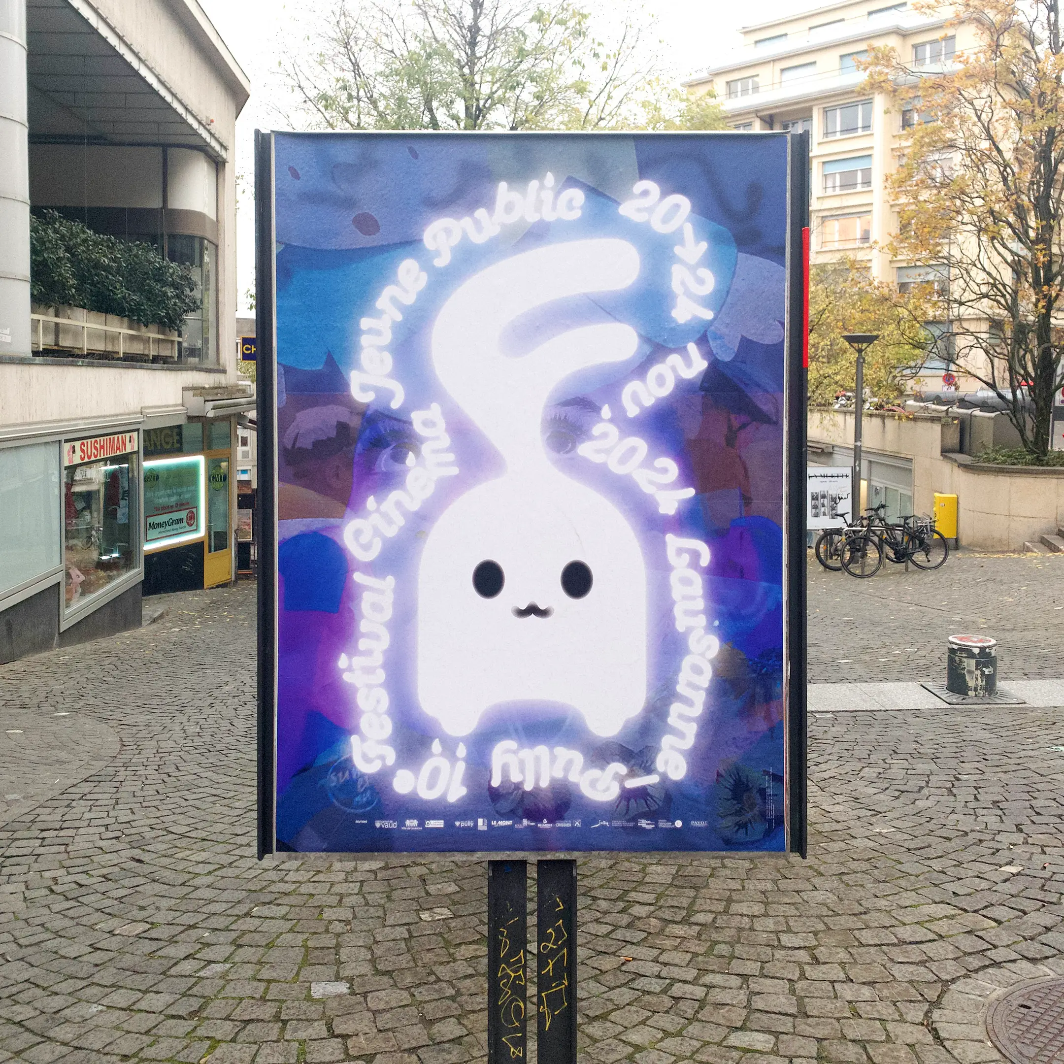 Photo montrant l’affiche de l’édition 2024 du Festival Cinéma Jeune Public dans la rue. Graphisme: Niels Wehrspann